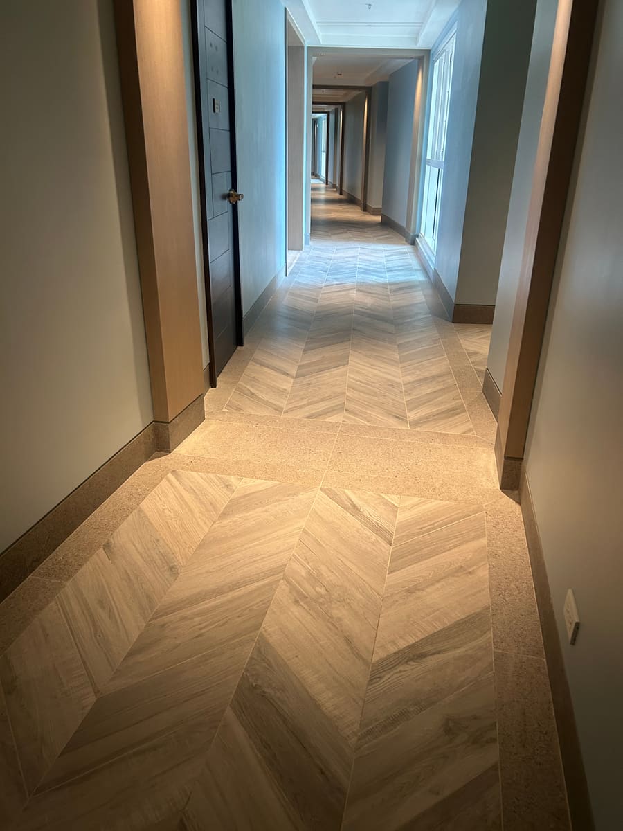 Chevron porcelain corridor installed in phases with consistent shade