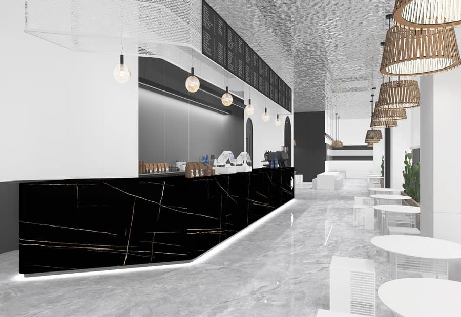 Commercial counter in dark-veined sintered stone under warm lighting